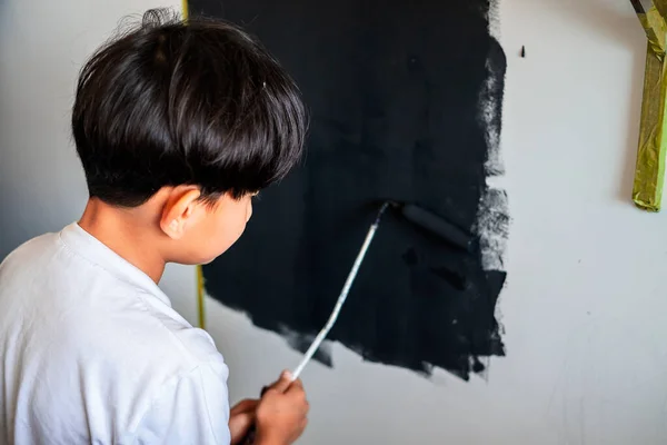 Criança Pintando Uma Parede Cor Preta Vista Por Trás — Fotografia de Stock