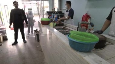 Yerel balık pazarındaki müşteriler ve işçiler.