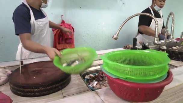 Trabalhador embalando o peixe na loja local do mercado de peixe. As filmagens podem conter ruído devido à pouca luz. — Vídeo de Stock