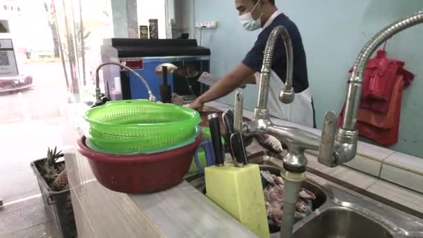 Zona de corte en la tienda de pescado local. Trabajadores ocupados en el fondo. Las imágenes pueden contener ruido debido a la poca luz. — Vídeos de Stock