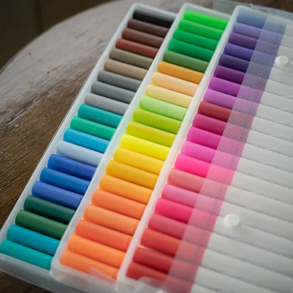 Stuks Kleurrijke Stiften Transparante Plastic Verpakking Een Houten Ondergrond — Stockfoto