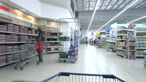 Bangi, Malajsie - březen, 2021 POV z nákupního košíku, nakupování v supermarketu Tesco Lotus store. Dělníci v obchodě. — Stock video