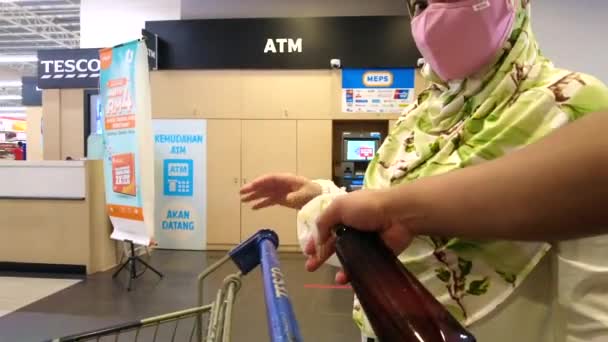 Kuala Lumpur, Malajsie - 28. března 2021 hygienizuje manipulaci s vozíkem supermarketu v Lotus 's Tesco. Covid-19 epidemie. Koncept sociálního distancování — Stock video