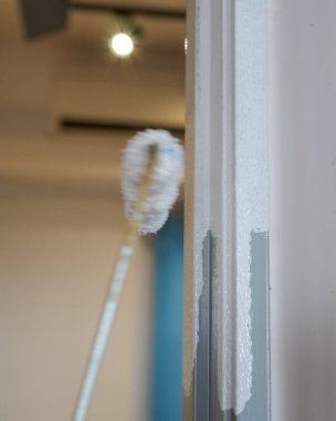 Kapı çerçevesinde beyaz boya var. Boyama projesi, evdeki DIY.