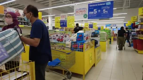 Bangi, Malasia - March, 2021 Vista interior de personas ocupadas haciendo compras de comestibles en el supermercado Tesco. De cerca. 4k — Vídeo de stock