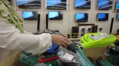 Bangi, Malezya - Mart 2021 Tesco Süpermarketteki eşyaları kontrol eden Müslüman kadın. Kapatın. 4k