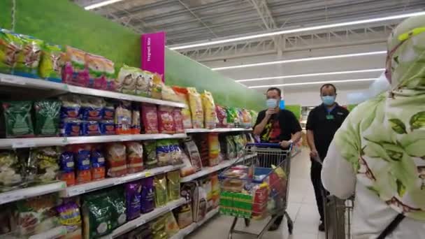 Bangi, Malaysia - Mars, 2021 POV av hijab muslimsk kvinna gör matinköp på Tesco Supermarket. Närbild. 4k — Stockvideo