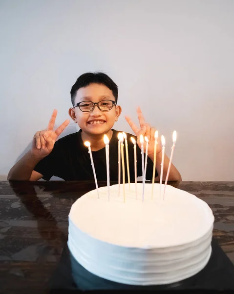 年轻的亚洲男孩戴着眼镜 在庆祝生日蛋糕的时候签了字 — 图库照片