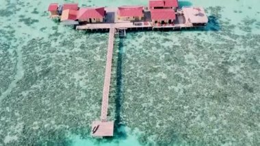Semporna, Sabah, Malezya 'daki mercan resifleriyle çevrili su dağ evi manzaralı..