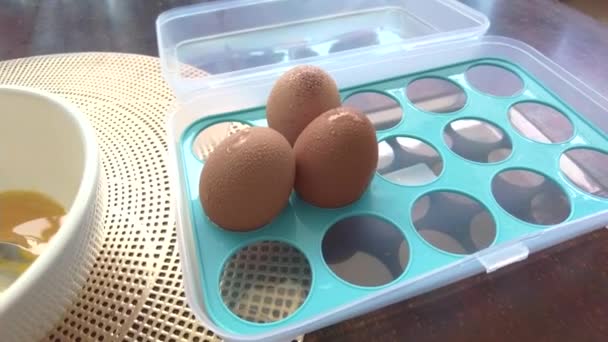 在一个塑料容器和一个碗中的冷凝壳中旋转的高角度鸡蛋视图 — 图库视频影像