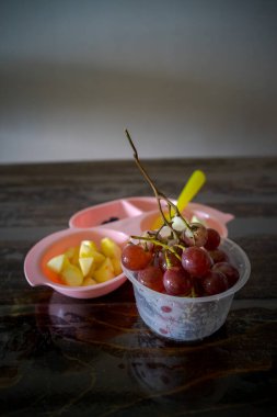 Çocuklar için eğlenceli yemek. Sağlıklı bir kahvaltı için elma, üzüm, yabanmersini ve guava şeklinde taze meyveli şirin bir araba tabağı..