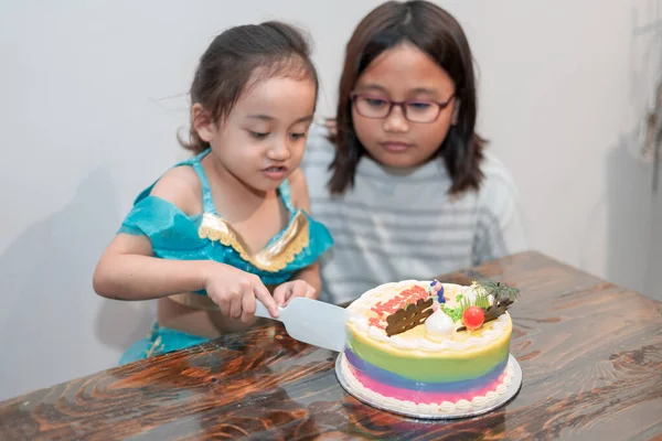 女の子が誕生日ケーキを切る 隔離中に家族と一緒に家で祝う — ストック写真