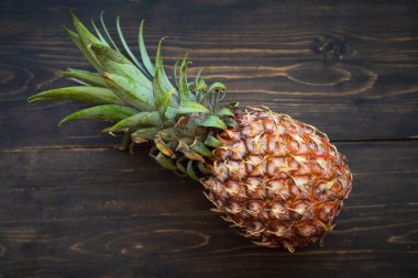 Tahta bir arka planda tek bir ananas..