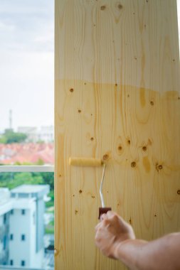Tahtadaki pürüzsüz palto boyası. Hareket tekerlekli fırça boyası.