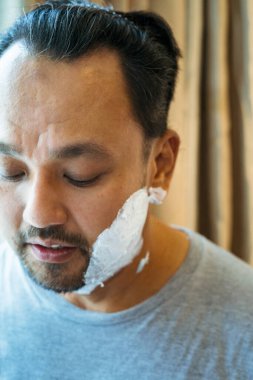 Yüzüne tıraş kremi süren bir adamın bulanık fotoğrafı..