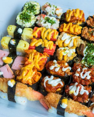 Beyaz arka planda servis edilen çeşitli suşi çeşitleri..