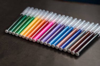 Koyu arkaplanda renkli işaretler var. Eğitim, öğrenim, yaratıcılık, sanat ve zanaat kavramı.