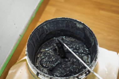 Konteynırda siyah boyalar olan paten boyası..