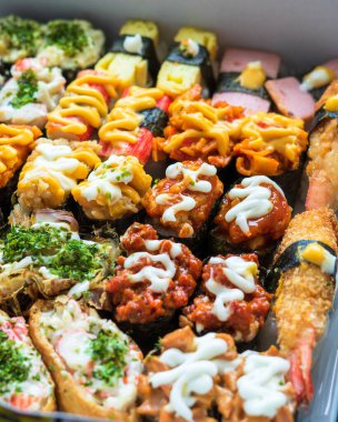 Beyaz arka planda servis edilen çeşitli suşi çeşitleri..