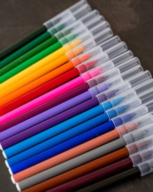 Koyu arkaplanda renkli işaretler var. Eğitim, öğrenim, yaratıcılık, sanat ve zanaat kavramı.