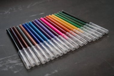 Koyu arkaplanda renkli işaretler var. Eğitim, öğrenim, yaratıcılık, sanat ve zanaat kavramı.