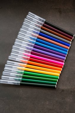 Koyu arkaplanda renkli işaretler var. Eğitim, öğrenim, yaratıcılık, sanat ve zanaat kavramı.