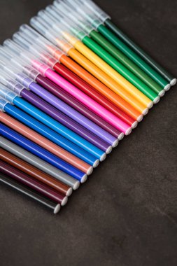 Koyu arkaplanda renkli işaretler var. Eğitim, öğrenim, yaratıcılık, sanat ve zanaat kavramı.