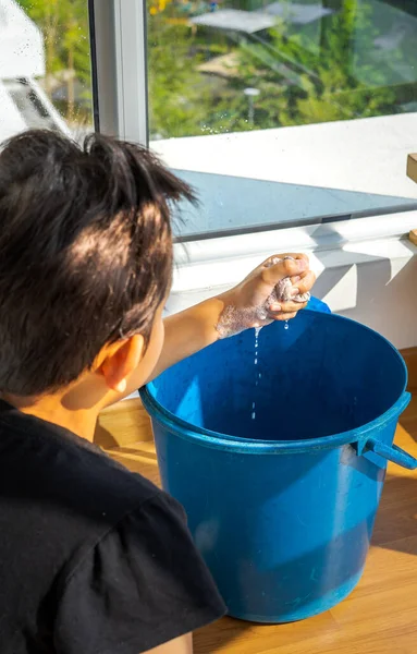 Unge Gutt Melker Filler Med Såpebobler Blå Bøtte Hjemmerengjøringskonsept Ved – stockfoto