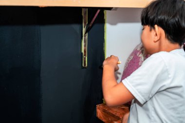 Küçük bir çocuk tarafından siyaha boyanmış duvar..