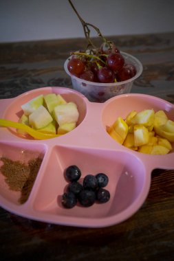 Çocuklar için eğlenceli yemek. Sağlıklı bir kahvaltı için elma, üzüm, yabanmersini ve guava şeklinde taze meyveli şirin bir araba tabağı..