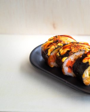 Kore yemeği, gimbap veya ahşap bir arka planda bir tabakta kimbap..