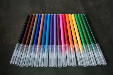 Koyu arkaplanda renkli işaretler var. Eğitim, öğrenim, yaratıcılık, sanat ve zanaat kavramı.