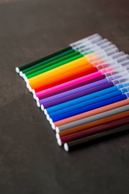 Koyu arkaplanda renkli işaretler var. Eğitim, öğrenim, yaratıcılık, sanat ve zanaat kavramı.