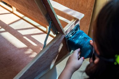 Sanatçının atölyesindeki bir makineyle ahşap zımparalarken çekilmiş bulanık bir fotoğraf..