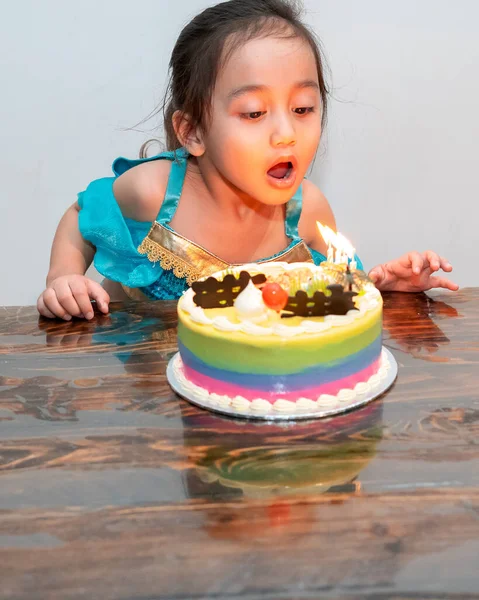 女の子は誕生日ケーキにろうそくを吹いている 隔離中に自宅で祝う — ストック写真