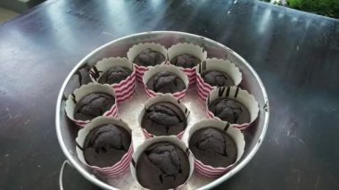 Koyu ahşap masadaki tepsi fırınında lezzetli çikolatalı keklere yavaşça yakınlaş.