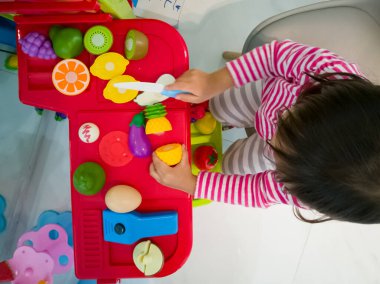 Yeni yürümeye başlayan çocuğun oyuncaklarıyla yemek pişirme görüntüsü..