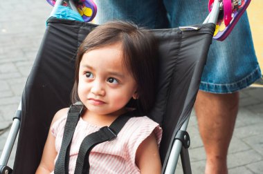 Bebek arabasında oturan Asyalı bir çocuğun portresi..