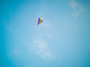 Renkli uçurtma rüzgar mavi gökyüzünde uçan.