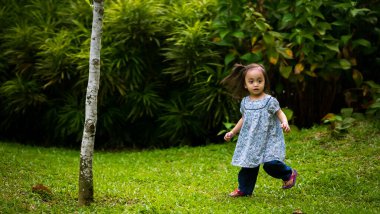 Mutlu Asyalı çocuk parkta açık havada oynuyor..