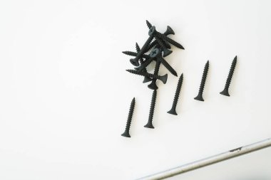 Beyaz arka planda izole edilmiş aynı boyutta siyah vidalar..