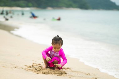 Sahilde oynayan küçük Asyalı kız. Tatil ve rahatlama konsepti..