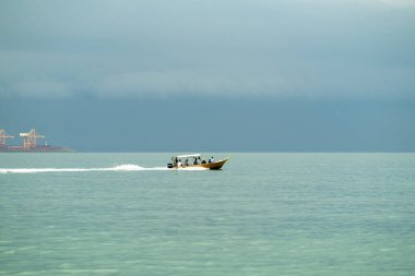 Denizi hızla geçen nakliye gemilerindeki insanlar..
