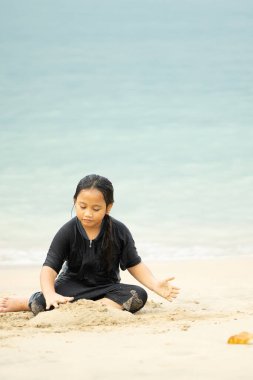 Sahilde oynayan küçük Asyalı kız. Tatil ve rahatlama konsepti..