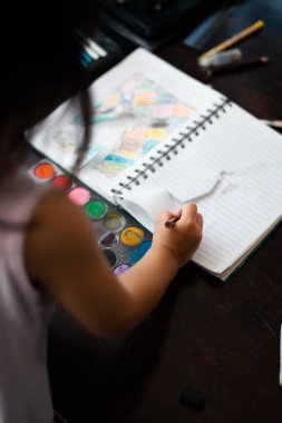 Küçük sevimli Asyalı kızın portresi. Yaratıcı oluyor ve bir resim üzerinde çalışıyor. Güven Olumlu Özgürlük Yaratıcı Kavram Ol.