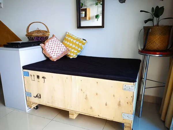 Büyük kargo ahşap sandığı bir dairedeki endüstriyel iç tasarıma uysun diye kanepeye yerleştirilmiş..