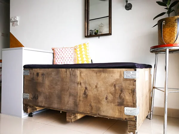 Büyük kargo ahşap sandığı bir dairedeki endüstriyel iç tasarıma uysun diye kanepeye yerleştirilmiş..