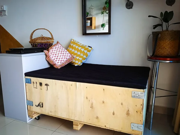 Büyük kargo ahşap sandığı bir dairedeki endüstriyel iç tasarıma uysun diye kanepeye yerleştirilmiş..