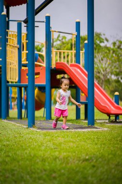 Mutlu Asyalı çocuk renkli oyun alanında eğleniyor..