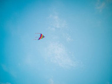 Renkli uçurtma rüzgar mavi gökyüzünde uçan.